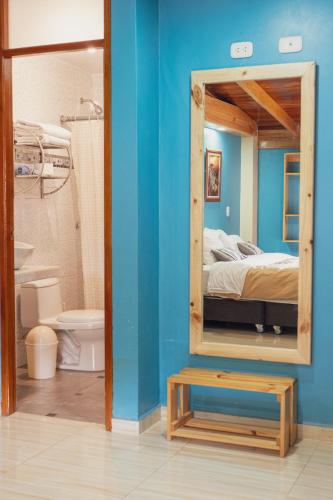 a room with a mirror and a bed and a bathroom at Casa privada con vista a las montañas Dona Catta in Ollantaytambo