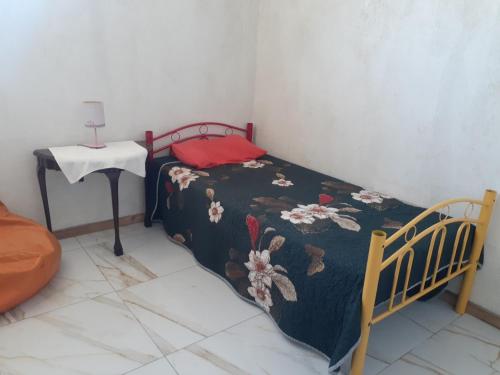 una piccola camera da letto con un letto e un tavolo di Bird Whistle a Zeekoevlei