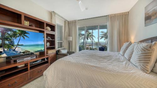 een slaapkamer met een bed en een grote televisie bij Waterfront, Spa/Pool, Private Paradise On LBK! in Longboat Key