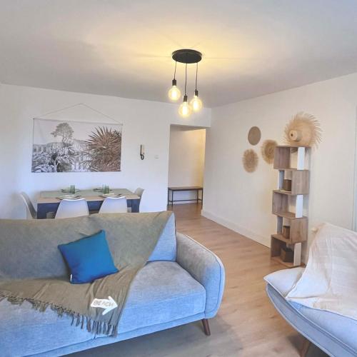 a living room with a couch and a dining room at La Varangue bleu T3 Aéroport Sainte Marie in Sainte-Marie