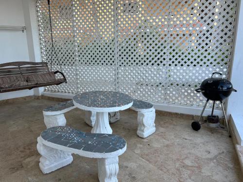 uma mesa e bancos num quarto com uma janela em Condo 1bdr 1bth with garden em Punta Cana