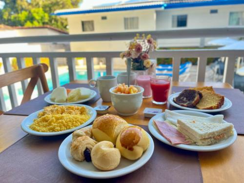 a table with plates of breakfast foods on it at El Aram Ponta Negra in Natal