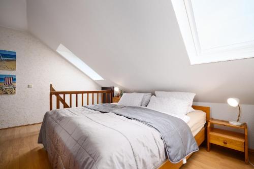 een slaapkamer met een bed en een groot raam bij Deichweg 33 Käptns Kajüte in Kalifornien