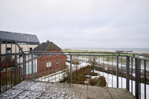 een balkon met een bakstenen gebouw en de oceaan bij Deichweg 33 Käptns Kajüte in Kalifornien