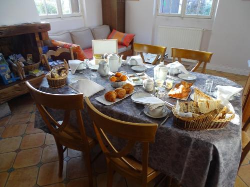 een tafel met een blauw tafelkleed en manden met voedsel bij Chambre d'hôtes "Perle", Communs de Bon Hôtel in Ligny-le-Ribault