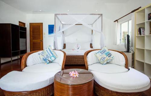 a living room with two chairs and a bed at Right along the shoreline ! in Boracay
