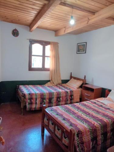 a hotel room with two beds and a window at HOSTAL LUPITA in Iruya