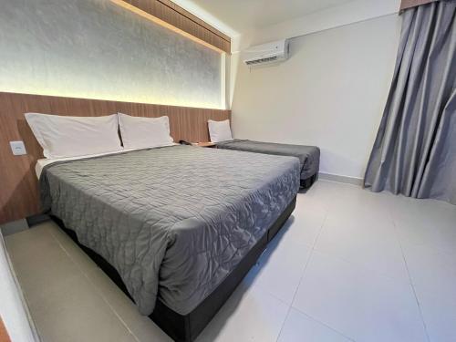 a hotel room with a bed and a window at El Aram Ponta Negra in Natal