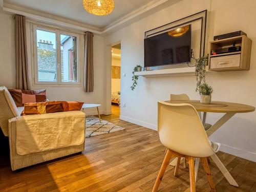 a living room with a table and a couch at T2 avec bain à remous en plein centre de Chartres in Chartres
