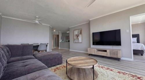 un soggiorno con divano e TV a schermo piatto di Odeon Ocean View a Strand