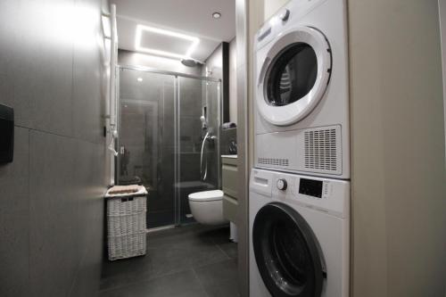 Un baño con lavadora y un inodoro. en Apartamento Moderno a 5 min del Funicamp, 1-2, en Encamp