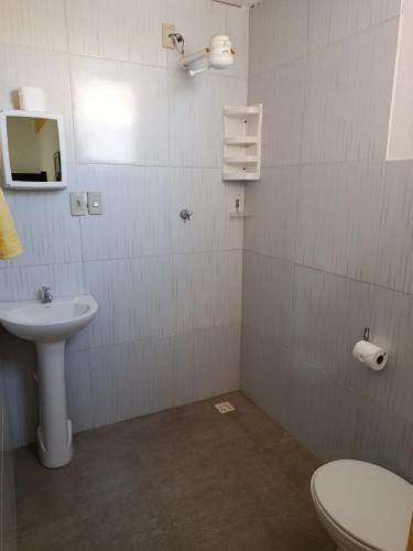 a bathroom with a toilet and a sink at Pé na Terra - Suítes in São Miguel do Gostoso