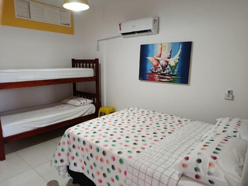 a bedroom with two bunk beds and a bed with polka dots at Pé na Terra - Suítes in São Miguel do Gostoso