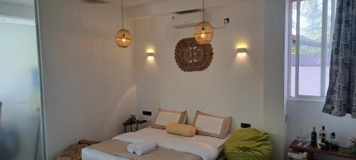 Cactus reef في آهانغاما: غرفة نوم بها سرير ومصباحان على الحائط