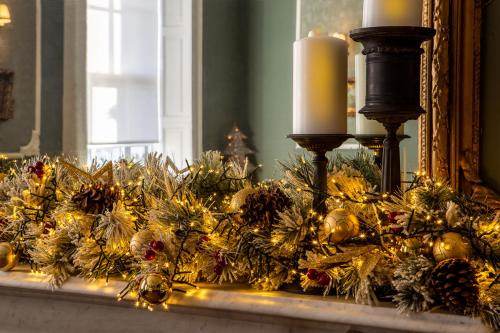 a mantle with christmas decorations and candles on it at Hotel St George by Nina in Dublin