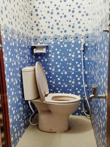 a bathroom with a toilet with blue and white polka dots at Hotel Al-Hayat Abasik in Dhaka