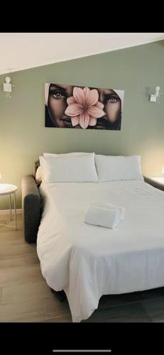 a bedroom with a white bed with a flower on the wall at PsApart in Augusta