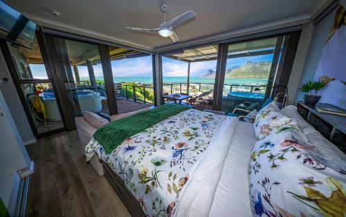a bedroom with a bed with a view of the ocean at The Butterfly Villa in Pringle Bay