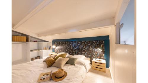 ein Schlafzimmer mit einem großen weißen Bett mit blauem Kopfteil in der Unterkunft Slow Village Saint-Martin-de-Ré in Saint-Martin-de-Ré