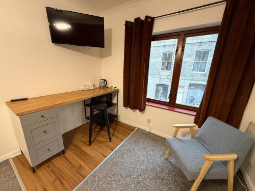a room with a desk and a tv and a chair at Core Citi Lets, Guild Street Rooms in Aberdeen