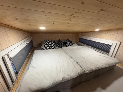 a bed in a small room with a wooden ceiling at KE-Tiny Haus Paulchen in Oerlenbach