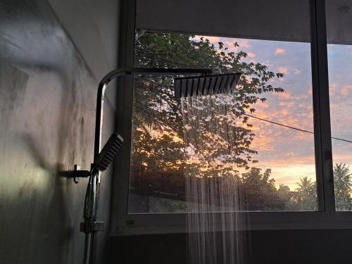 a bathroom window with a view of a sunset at Cactus reef in Ahangama