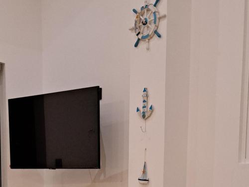a wall with a tv and a clock on a wall at Cactus reef in Ahangama