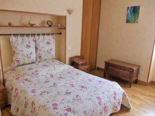 1 dormitorio con 1 cama grande con flores rosas en Gîte lumineux, en Antaignagues