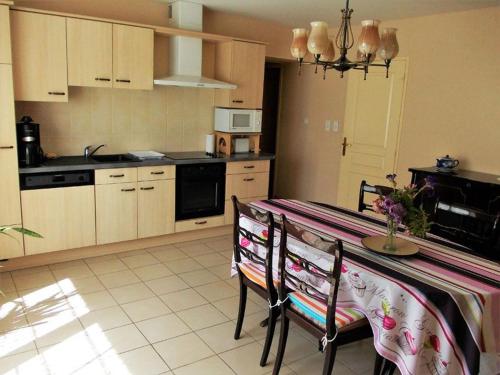 una cocina con mesa y 2 sillas y una cocina con en Gîte lumineux, en Antaignagues