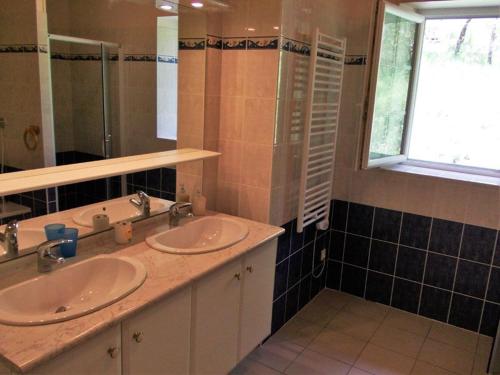 Baño con 2 lavabos, espejo y ventana en Gîte lumineux, en Antaignagues