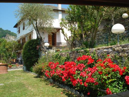 a garden with red flowers in front of a building at Rosa dei Venti in Rapallo