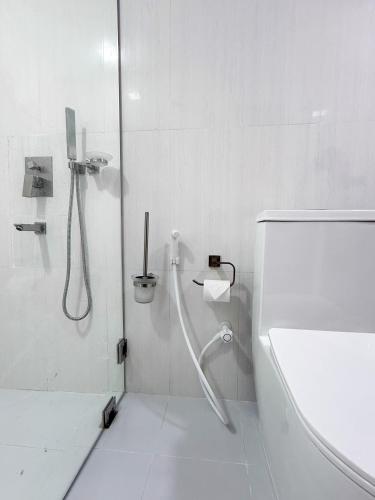 a white bathroom with a shower and a toilet at Bonthi Grand in Gemanafushi