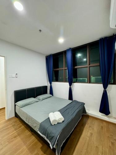 Un dormitorio con una cama con dos toallas encima. en Make Memories 2BR Family Suite Kuching, en Kota Samarahan