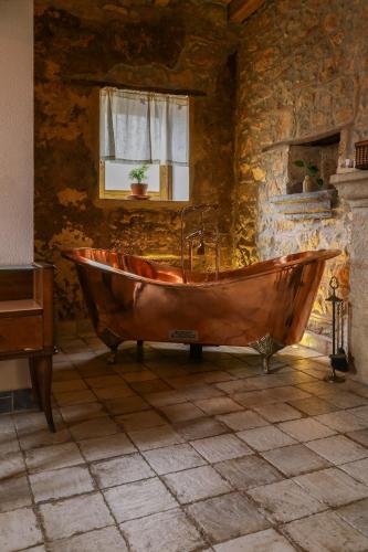 a wooden tub in a room with a stone wall at Paolino848 in Trentinara