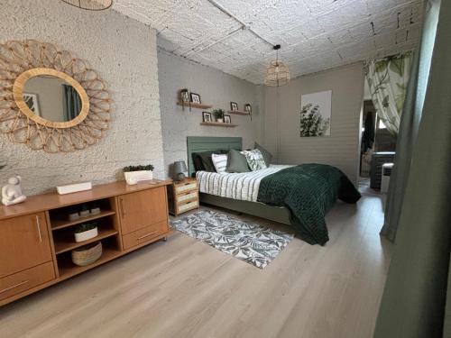 Un dormitorio con una cama, una cómoda y un espejo. en NBs Sage & Stone Nest, en Edenvale