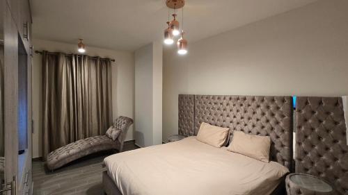 una camera da letto con un letto grande e una sedia di Luxurious flat in Adma ad Admā