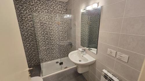 un bagno con lavandino e doccia con specchio di Luxurious flat in Adma ad Admā