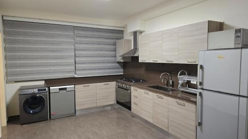 una cucina con frigorifero e lavatrice di Luxurious flat in Adma ad Admā