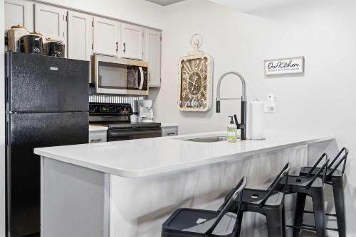 a kitchen with a white counter and black appliances at Ozark Overlook Escape - For 6 in Branson West