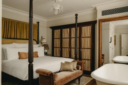 a bedroom with a bed and a chair and a sink at The Ned in London