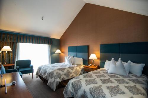 a hotel room with two beds and a window at The Bard's Inn - BW Signature Collection by Best Western in Ashland