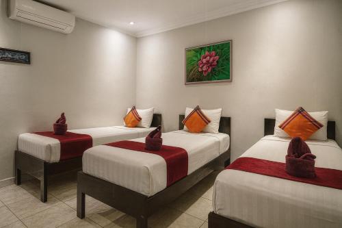 two twin beds in a room with at Cahaya Adrian Near Komodo Airport in Labuan Bajo