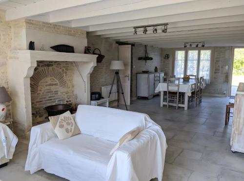 ein Wohnzimmer mit einer weißen Couch und einem Kamin in der Unterkunft Gite La Ferme - Les Gites Du Moulin in Saint-Hilaire-la-Palud