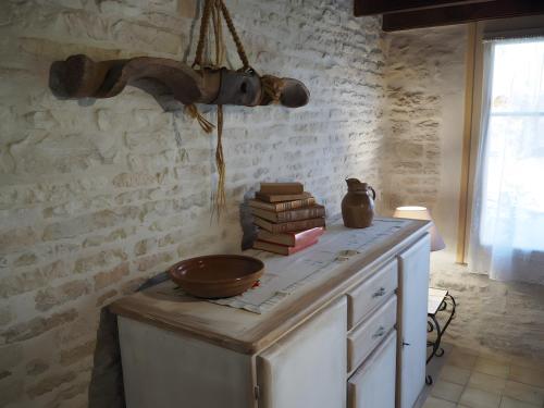 Eine Küche mit einer Schüssel und Büchern auf der Theke in der Unterkunft Gite La Ferme - Les Gites Du Moulin in Saint-Hilaire-la-Palud