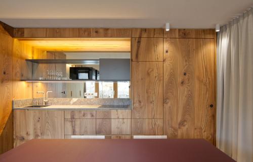 una cucina con pareti in legno, lavandino e bancone di Sarti Apparment a San Candido