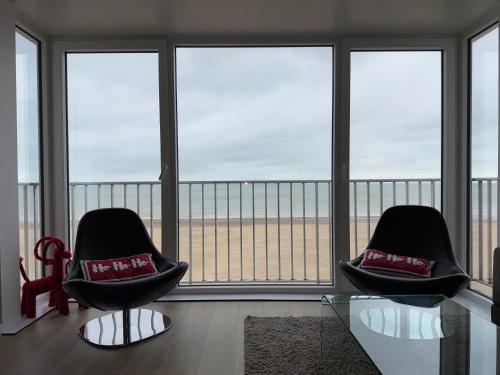 two chairs in a room with a view of the ocean at Malouki Koksijde - 4 star appartment with magnificent sea view in Koksijde