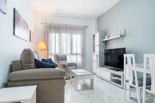 a living room with a couch and a television at Apartamento Deluxe 1 Room Piscina Parking LuxSevilla Bormujos in Bormujos