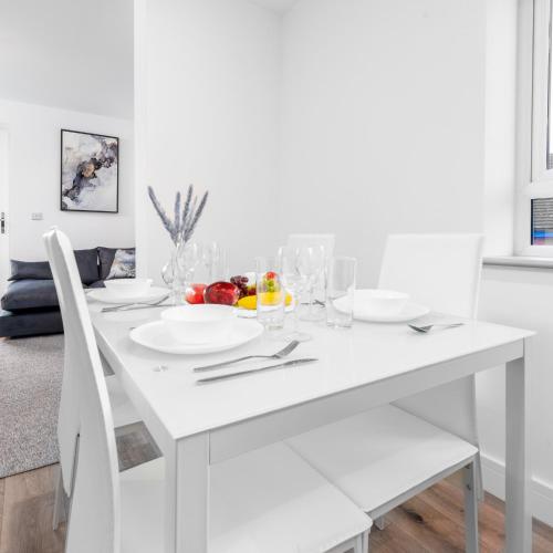 a white dining room table with a bowl of fruit on it at Stylish 2 Bed Apartment - Balcony - Private Parking - Netflix 4MC in Birmingham