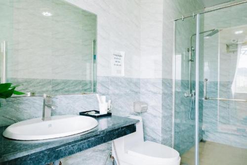 a bathroom with a sink and a shower and a toilet at Brother Hotel & Travel in Cat Ba