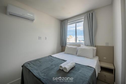 Apto a 750m do Mar c/ varanda e churrasq. GVT2105 في ميا برايا: غرفة نوم صغيرة مع سرير مع نافذة